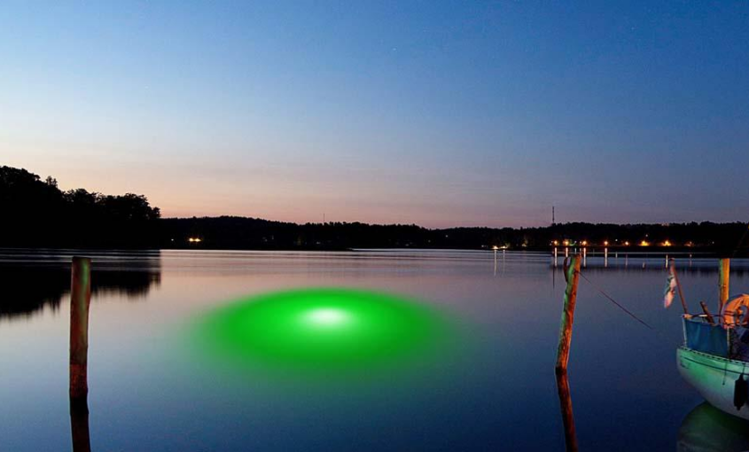 A large waterfront property with green underwater lights installed.