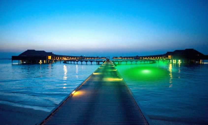 A green light next to a dock in water