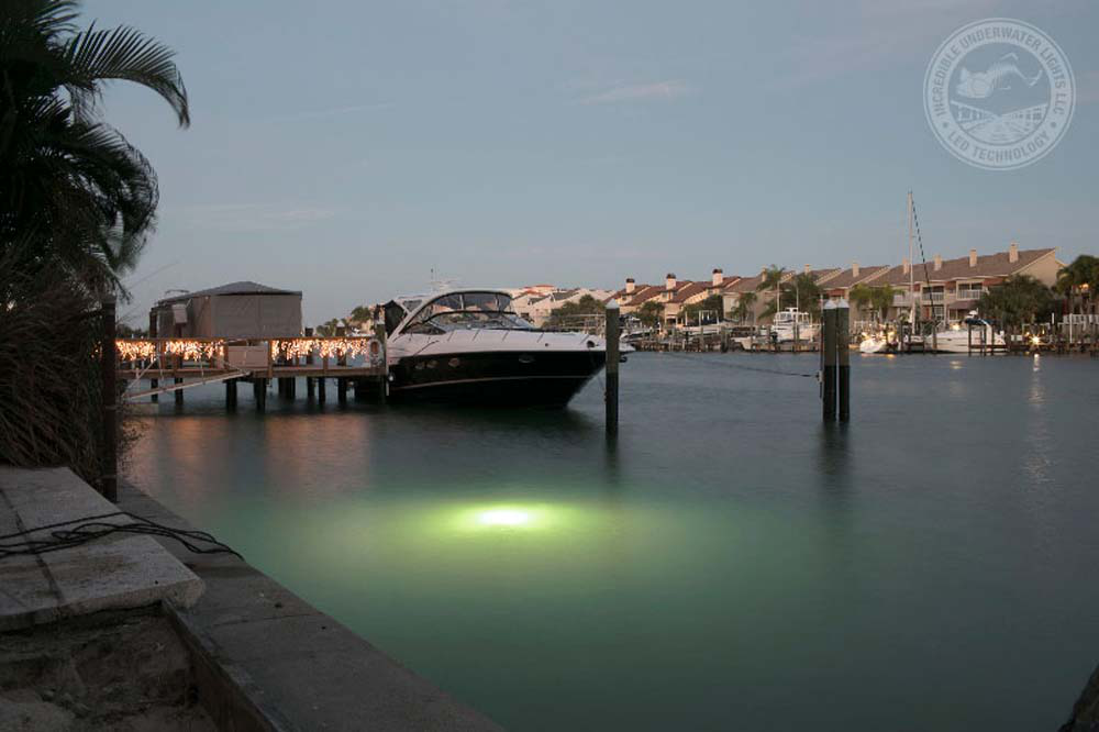 A boat parked near the dock with a green colored LED Light.
