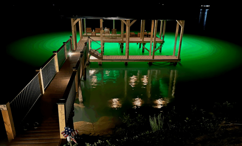 A dock lit with underwater green lights
