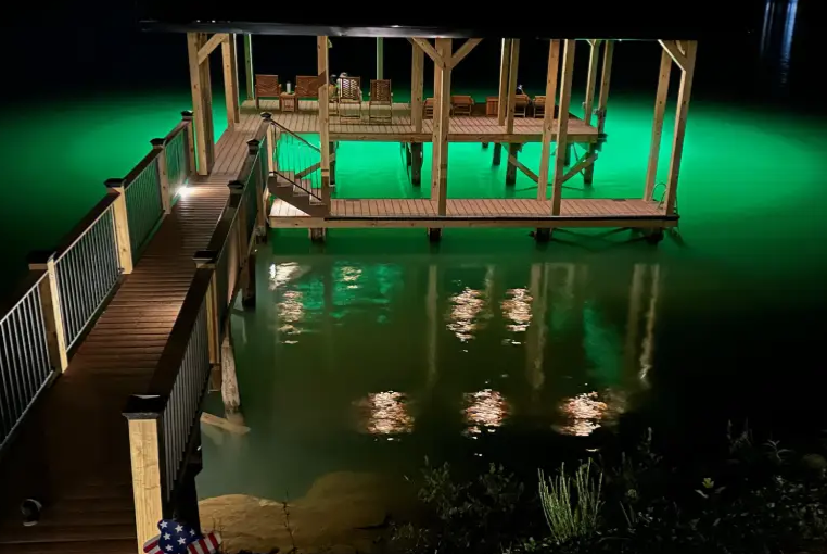 A large dock area with lights and underwater green lights.