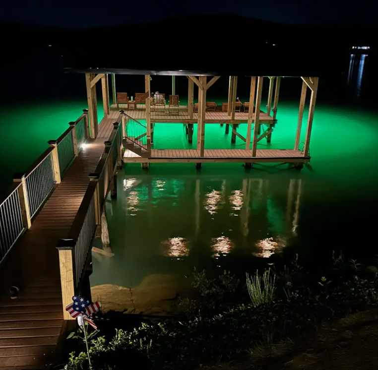 A large dock area with lights and underwater green lights.