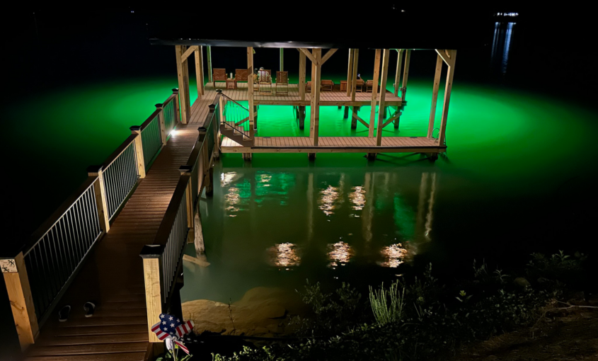 green underwater dock lights illuminating the fishing area beneath the waterfront dock at night